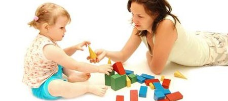 vrouw speelt met kind en blokken
